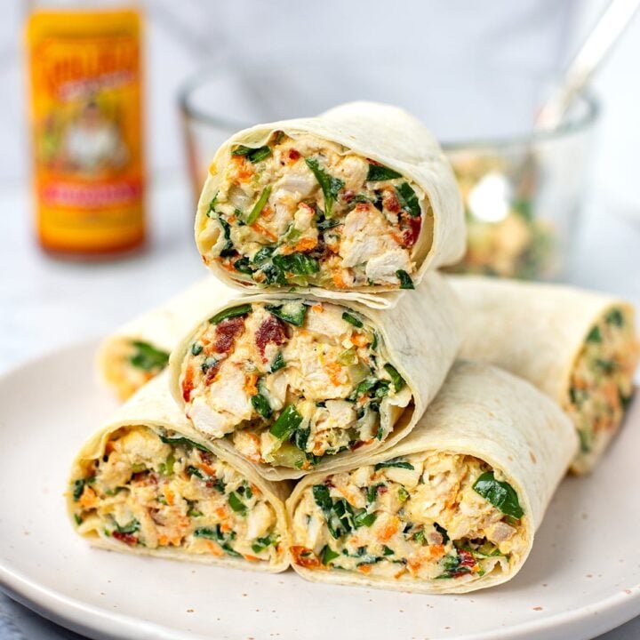stack of chicken salad wraps on a plate.