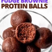 chocolate protein balls in a glass serving dish with one bitten, with text overlay.