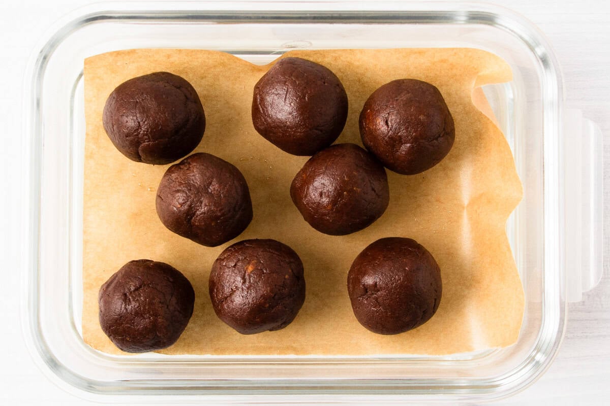 chocolate protein balls in a glass meal prep container.