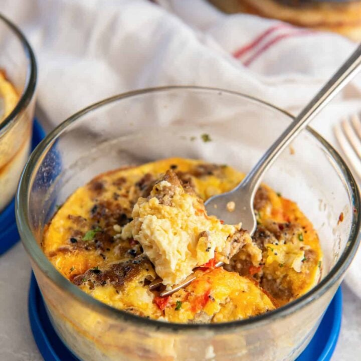 egg bake with sausage and red pepper in an food storage container with a fork.