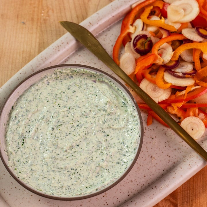 creamy vegetable dip next to cut vegetables.