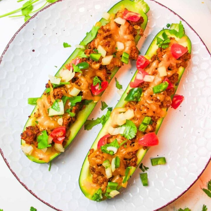 two halves of zucchini stuffed with meat and cheese.