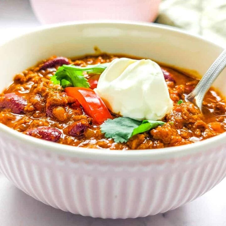 bowl of chili topped with sour cream.