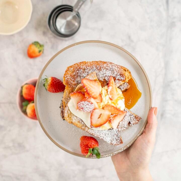 top view of high protein french toast topped with strawberries on a plate.