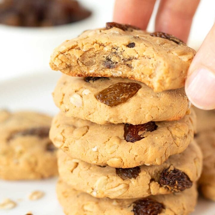 stack of oatmeal raisin protein cookies with the top one bitten.