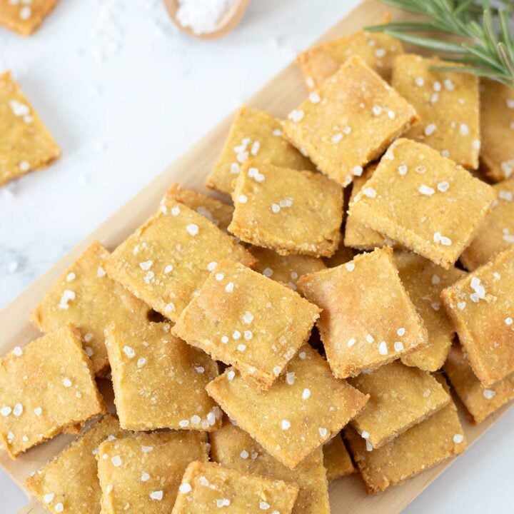 vegan chickpea crackers on a wood serving board.
