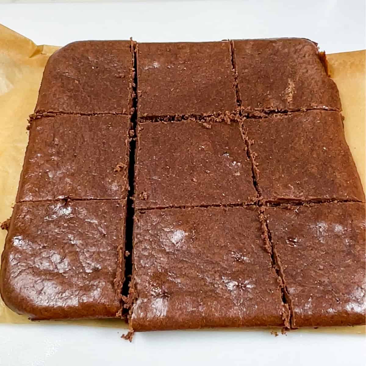 whey protein brownies on parchment, cut into 9 pieces.