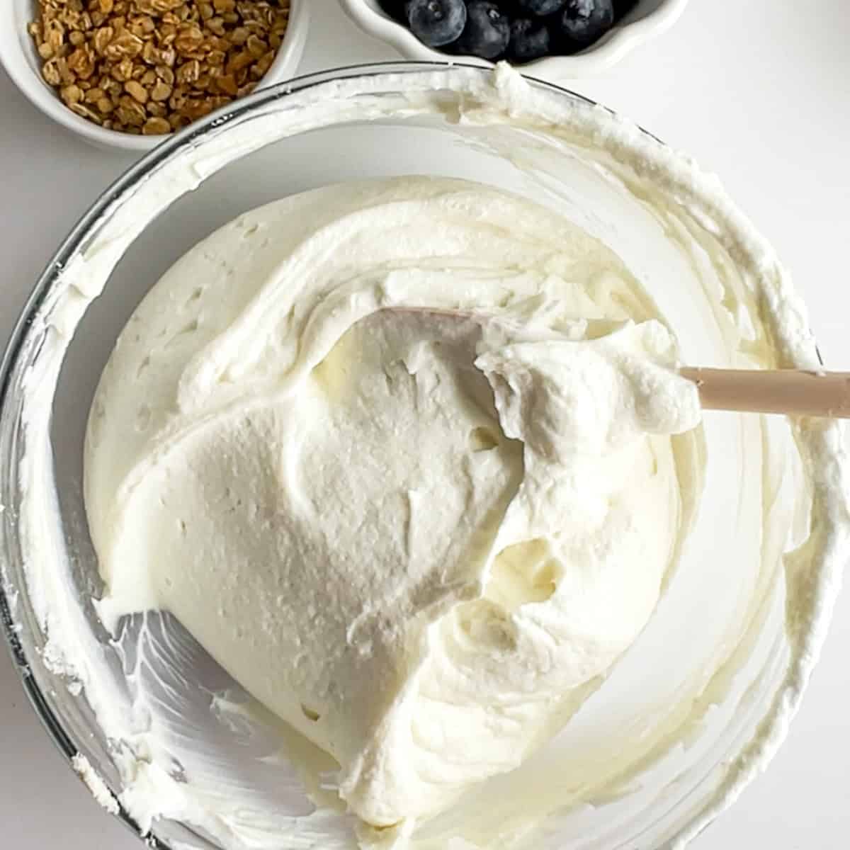 whey protein powder mixed with greek yogurt in a glass bowl.