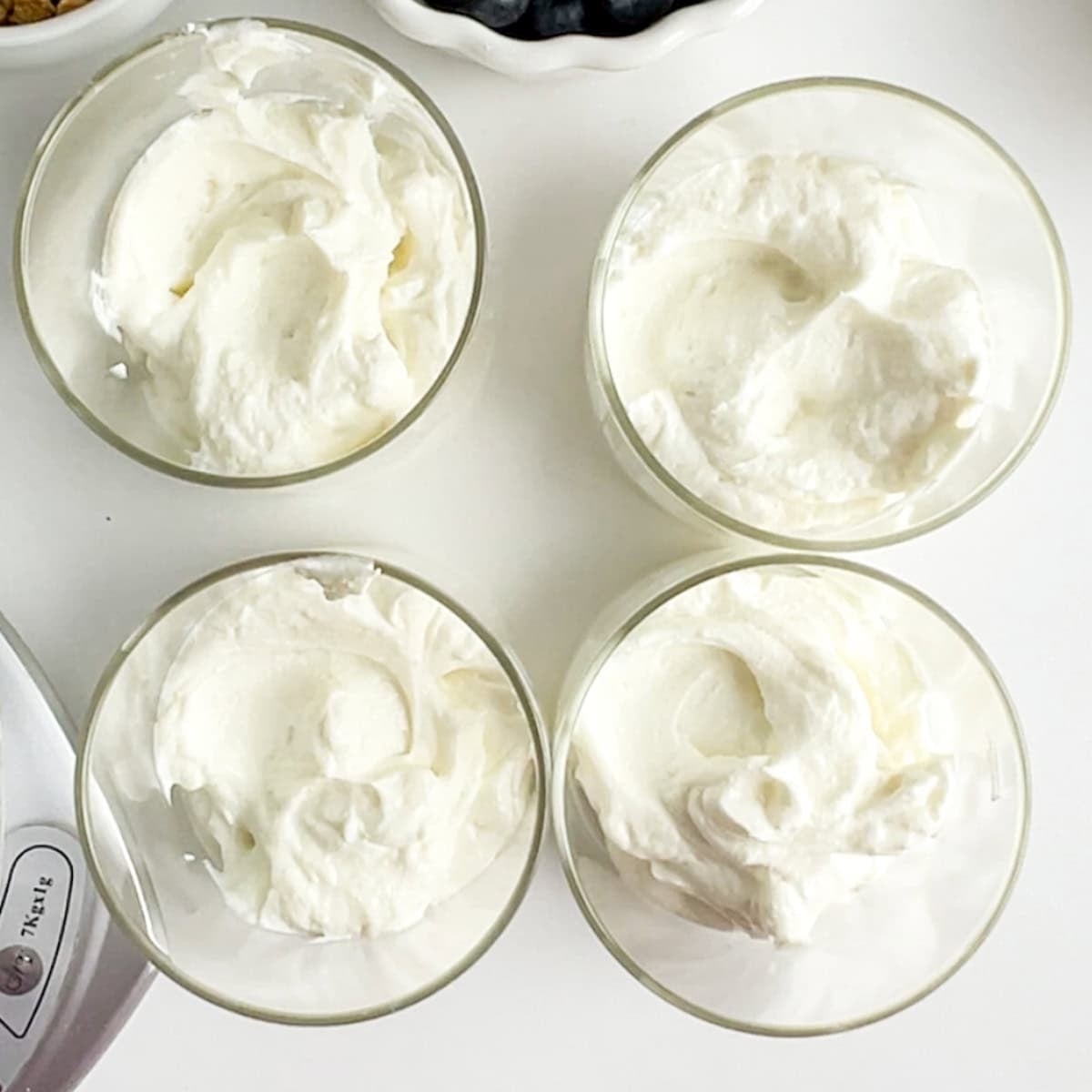 yogurt and protein mixture in the bottom of four jars.
