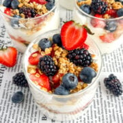 jars of high protein yogurt parfait with Greek yogurt, blueberries, strawberries, blackberries, granola, and honey.